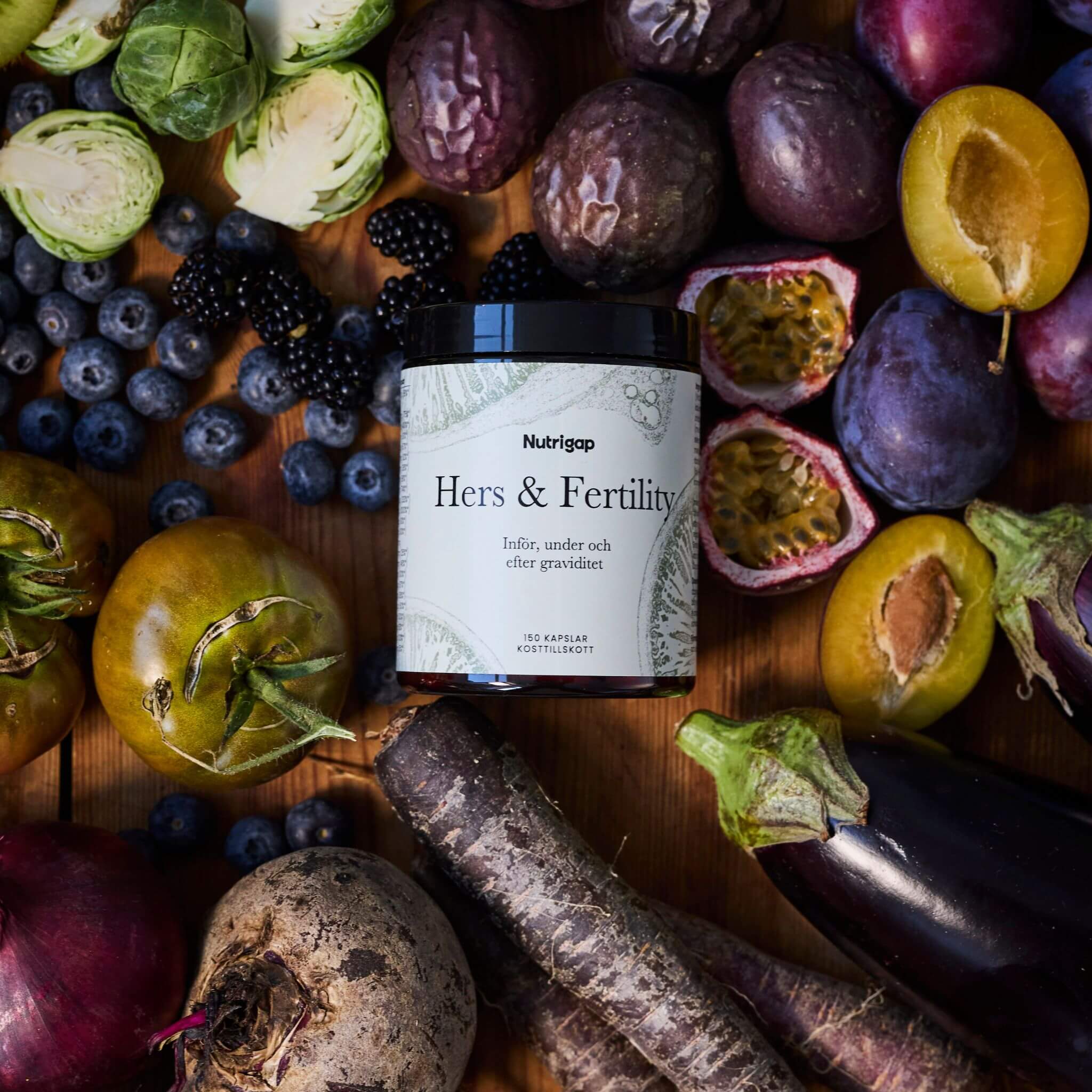 Burk med multivitamin omgiven av frukt, bär och grönsaker