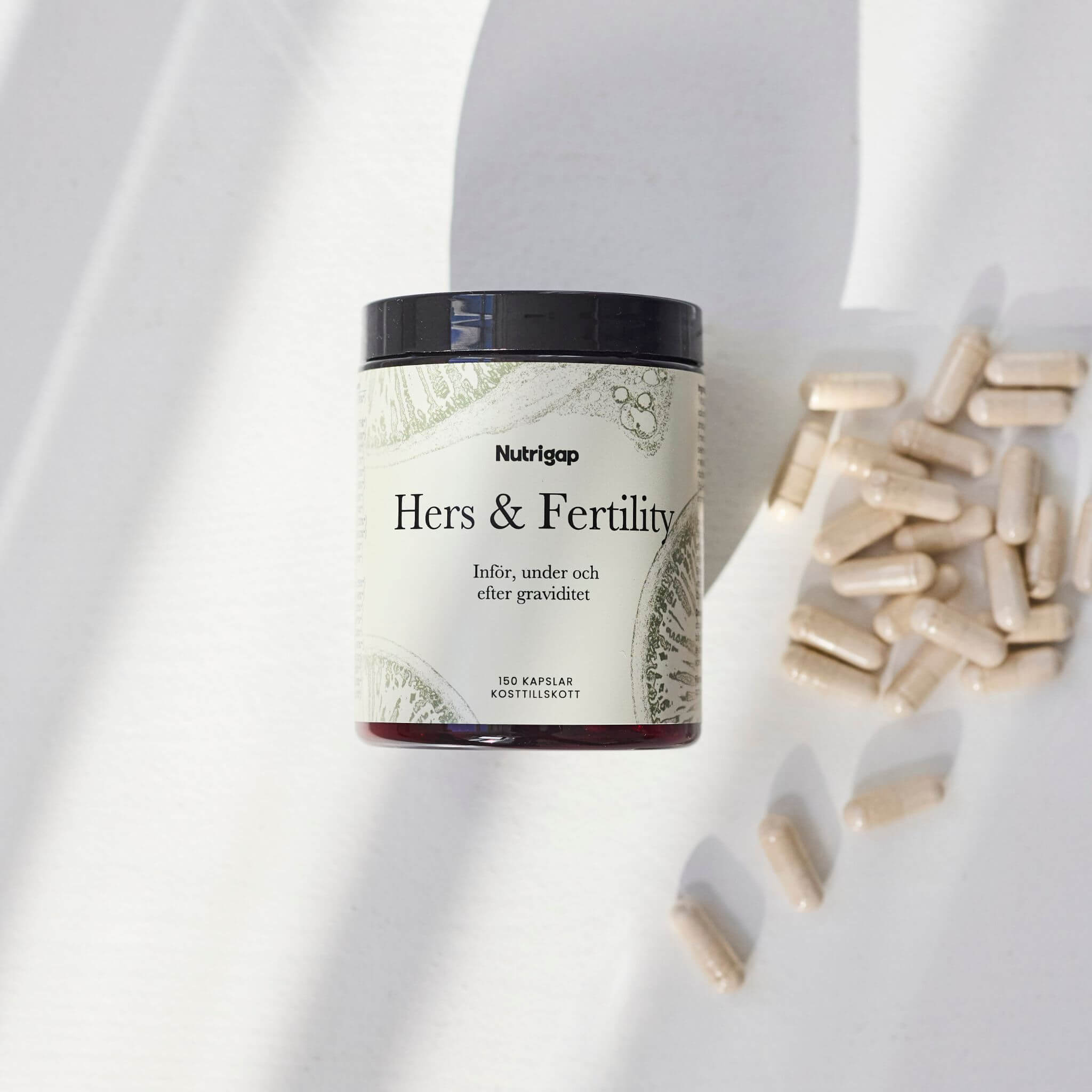 Burk med multivitamin i solljus med kapslar bredvid på vit bakgrund